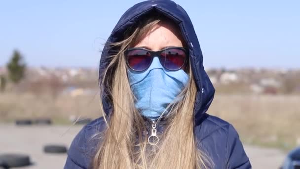 COVID-19 Coronavirüs sırasında mavi bir maske takan genç bir kız. — Stok video