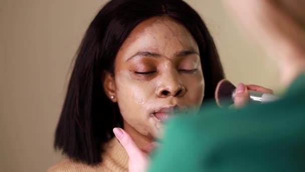 Beautiful African American girl doing face makeup — Stockvideo
