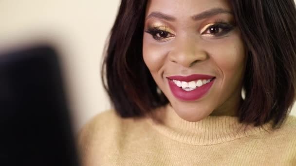 En ung afroamerikansk kvinna ler för Selfies, en flicka använder en smartphone för sociala nätverk — Stockvideo
