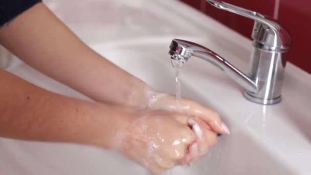 Woman washes her hands in the bathroom with water, soap and foam. — Video