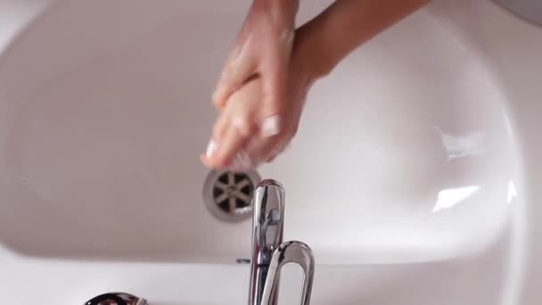 Woman washes her hands in the bathroom with water, soap and foam. — Video