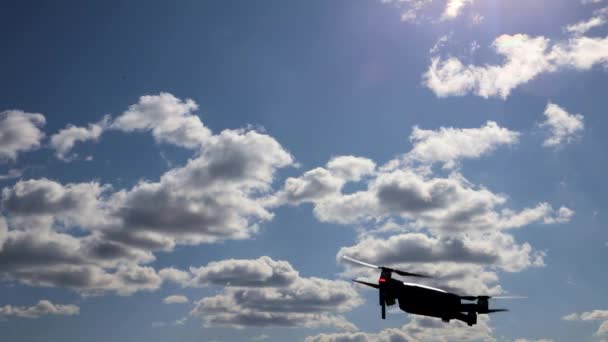 Drone manévruje na modré obloze. Létání a natáčení s drone kamerou — Stock video