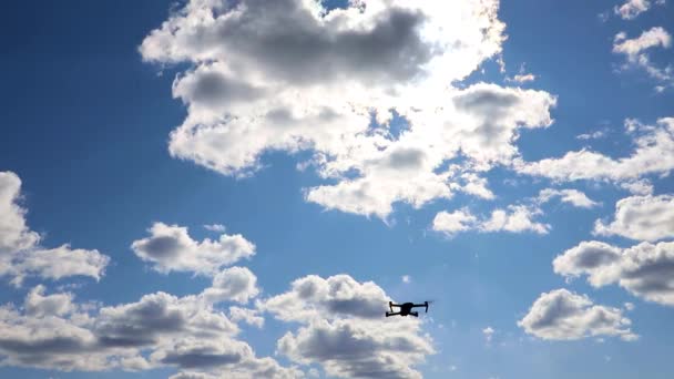 Drone manévruje na modré obloze. Létání a natáčení s drone kamerou — Stock video