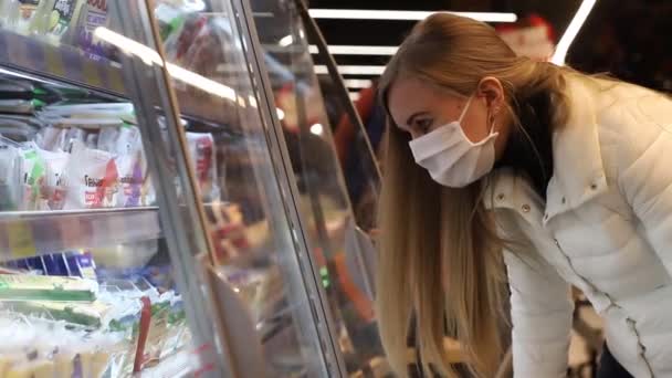 Genç bir kadın süpermarkette üretim yapmayı seçiyor — Stok video