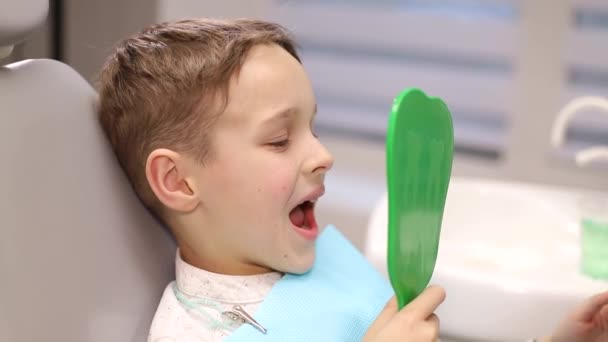 Ребенок у стоматолога, стоматолог осматривает молочные зубы. Лечение зубов, кариес у детей — стоковое видео