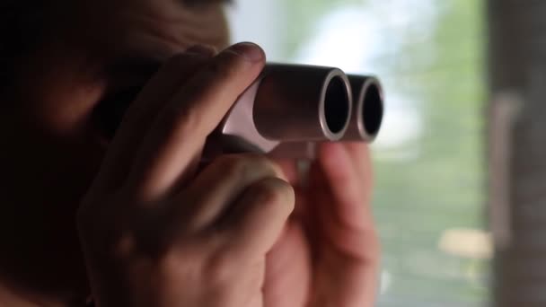 Man spying on people, using binoculars for observation — стоковое видео
