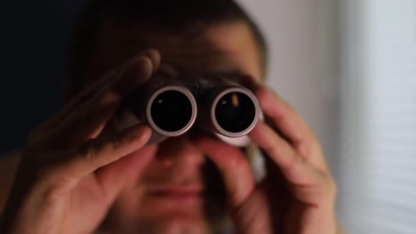 Muž špehuje lidi, používá dalekohled k pozorování — Stock video