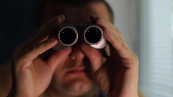 Mann spioniert mit Fernglas Menschen aus — Stockvideo