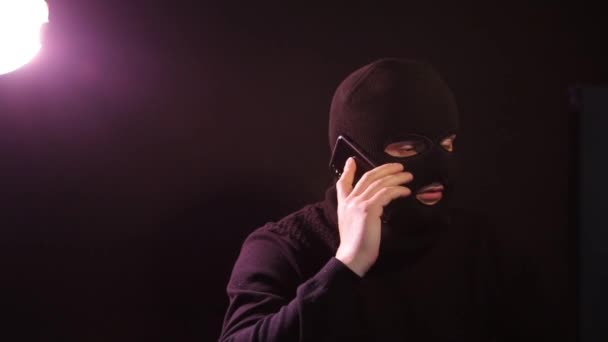 Un hacker muy peligroso. Un hombre con una cara enmascarada habla a la cámara . — Vídeos de Stock