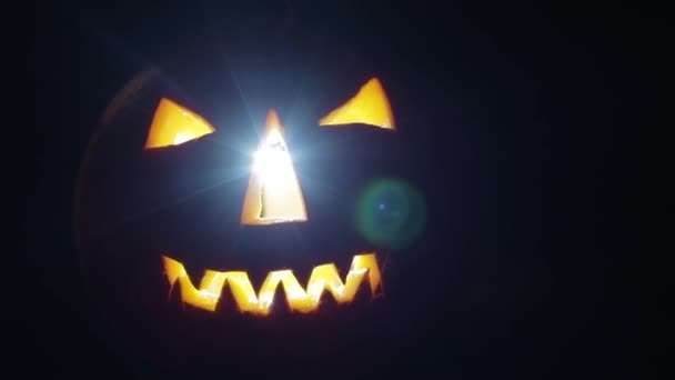 The American holiday Halloween pumpkin burns and glows in the dark — Stock Video