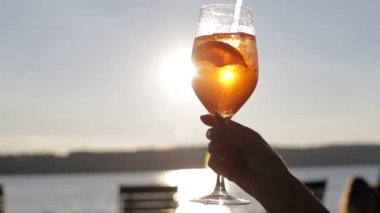 Kadın blogcu bir kafede telefonuyla bir bardak kokteylin fotoğrafını çekiyor..