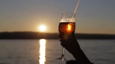 Kadın blogcu bir kafede telefonuyla bir bardak kokteylin fotoğrafını çekiyor..