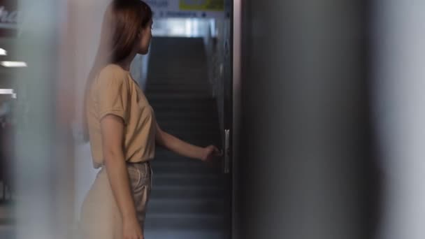 A nő megnyomja a lift hívógombját. A lift bejárata — Stock videók