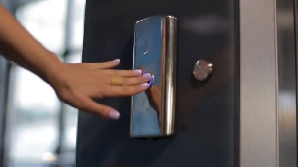 A nő megnyomja a lift hívógombját. A lift bejárata — Stock videók