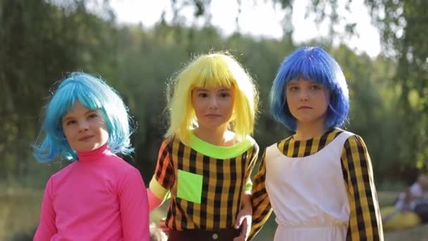 Teenage girl hugs them dressed in colorful wigs. — Video Stock