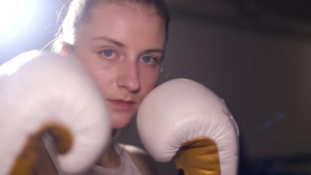 Uma mulher boxeadora treina socos, um dia de treinamento no salão de boxe, uma mulher rapidamente bate uma série — Vídeo de Stock