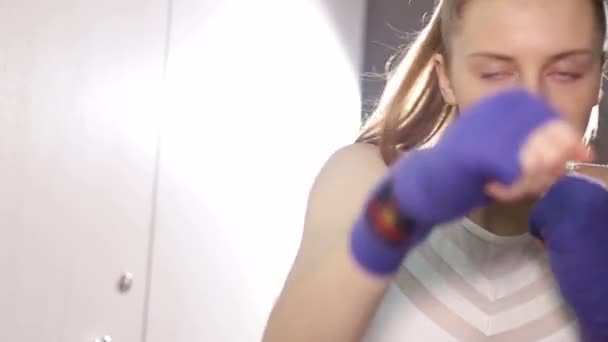 A woman boxer trains before a fight, a girl studies combat strikes. — Stock videók