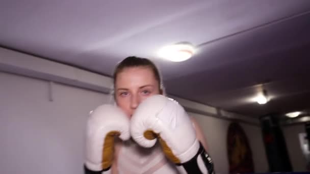 Kobieta bokser trenuje ciosy, dzień szkolenia w sali boksu, kobieta szybko pokonuje serię — Wideo stockowe