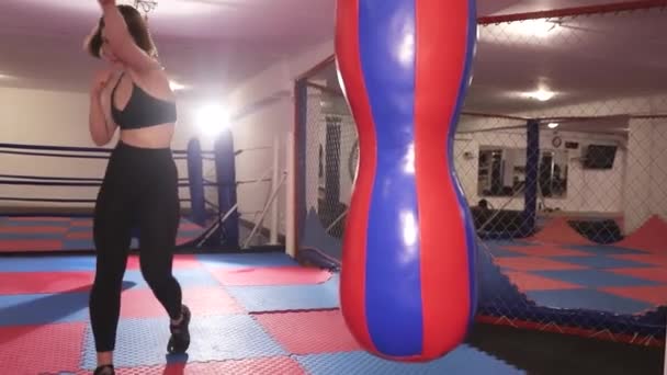 Mladá žena se učí boxovat v tělocvičně. Žena boxující v tělocvičně, bojující se stínem — Stock video