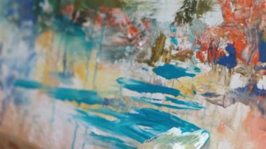 Close up of an artist painting a picture, he works in his art studio. Painting on white canvas
