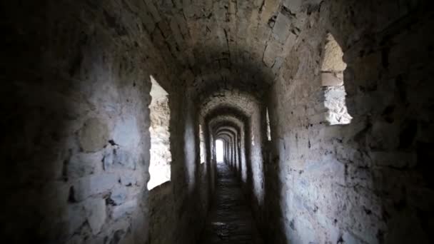 Forntida otroligt bevarade enorma stenmurar i slottet. Gå genom den mörka korridoren — Stockvideo