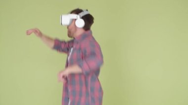 A man in a virtual reality headset dances happily, he has fun with a VR headset at a virtual party. The guy uses a simulation of glasses and moves to the beat of music