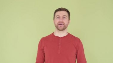 Smiling man with beautiful white teeth and stylish hairstyle on olive background in studio.