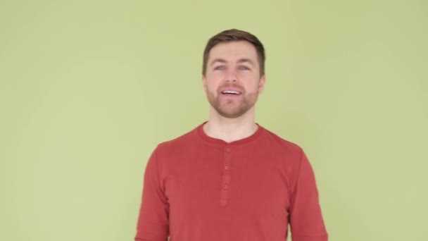 Smiling man with beautiful white teeth and stylish hairstyle on olive background in studio. — Stockvideo