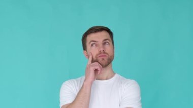 Mavi arka planda dalgın bir adam. Düşünce anı yaşayan meditasyon yapan bir adamın portresi.