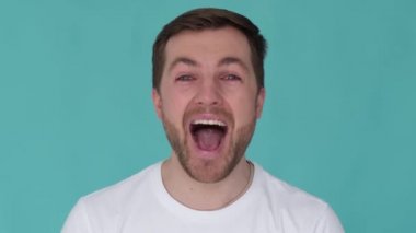 Close up of a man shouting into the camera lens with his mouth wide open
