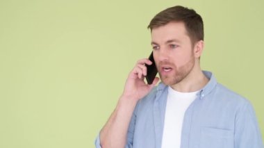 Aggressive young man talking on a smartphone, he angrily shouts into the phone