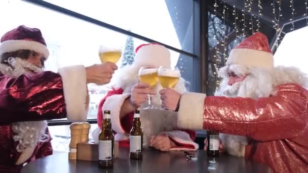 Eine Gruppe Weihnachtsmänner trinkt Bier in einem Café, Festlicher Zauber, Weihnachtsstimmung — Stockvideo