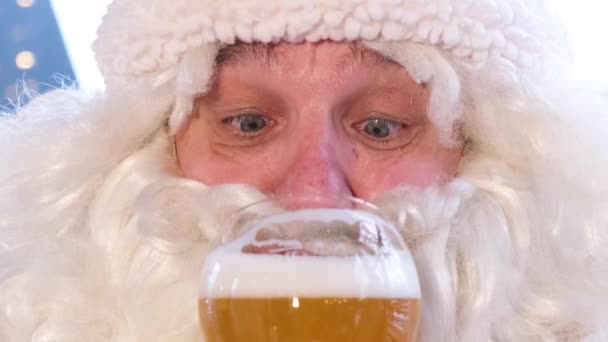 Stary Święty Mikołaj pije pyszne piwo ze szklanki, otwiera oczy w zaskoczeniu. Duch Świąt — Wideo stockowe