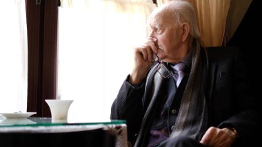 Yaşlı emekli şiddetli migren krizi geçiriyor. Yorgun ve yaşlı bir adam baş ağrısı çekiyor.