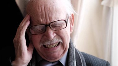 Yaşlı emekli mutfakta, sağlık sorunları için endişeleniyor..