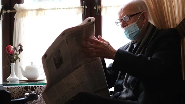 Velho avô lê a imprensa enquanto está sentado em um café. O pensionista está descansando — Fotografia de Stock