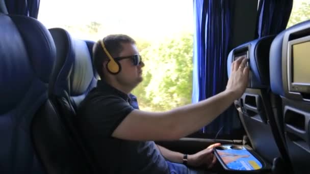 Doprava, cestovní ruch, silniční výlet a lidé koncept - šťastný mladý muž sedí v cestování autobusem nebo vlakem a při pohledu přes okno — Stock video
