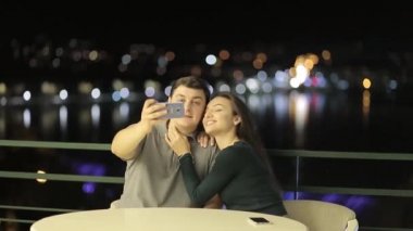 A sweet couple lovers kisses behind the citys lights. Valentines young couple on Valentines day