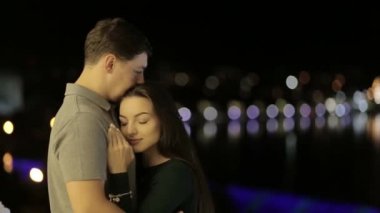 A sweet couple lovers kisses behind the citys lights. Valentines young couple on Valentines day