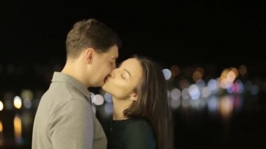 A sweet couple lovers kisses behind the citys lights. Valentines young couple on Valentines day
