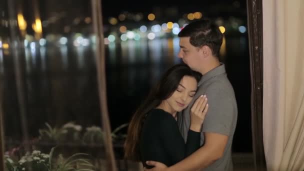 A sweet couple lovers kisses behind the citys lights. Valentines young couple on Valentines day — Stockvideo
