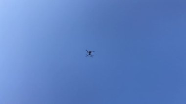 Mavi gökyüzüne karşı uçan bir dron. 4k video