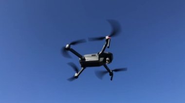 Mavi gökyüzüne karşı uçan bir dron. 4k video