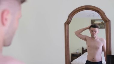 Aynaya bakıp saçını tarayan genç bir Avrupalı adamın portresi.