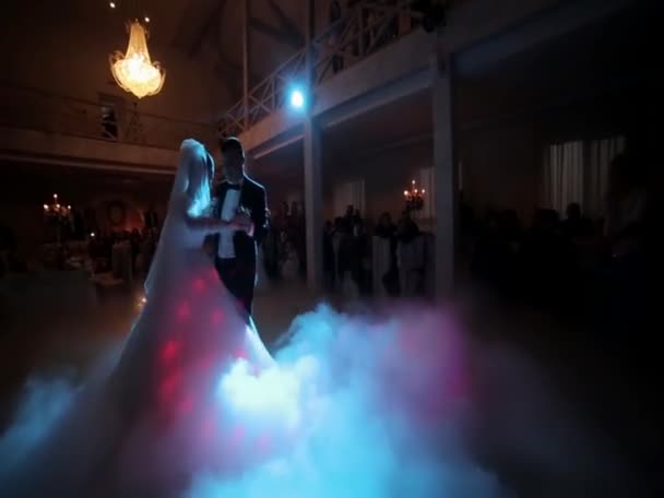 Amazing first wedding dance of newlyweds on low pink light and heavy smoke. Photo with noise — Stock videók
