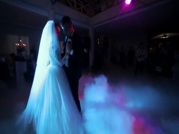 Amazing first wedding dance of newlyweds on low pink light and heavy smoke. Photo with noise — Wideo stockowe