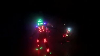 Laser show performance, dancers in led suits with LED lamp, very beautiful night club party.