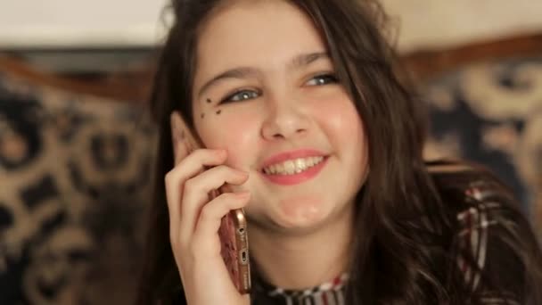 Teen girl is worried talking on a smartphone — стоковое видео