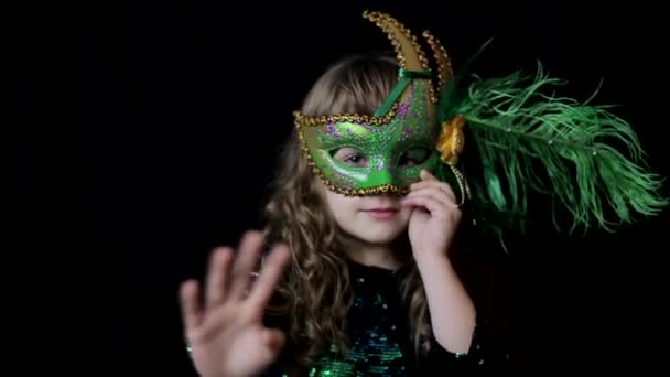 The face of a little girl in a traditional Venetian carnival costume and a wig, happy baby — Stockvideo