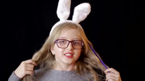Pretty teenager girl with Easter bunny ears holding lollipops in hands. Country wooden background. — Stockvideo